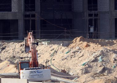 Giza, Mısır, 16 Ekim 2022: Giza Zed şehir projesindeki yeni binaların inşaat sahasında kazı kamyonu, bir inşaat sanayi bölgesinde ağır makine taşıma aracının seçici odağı