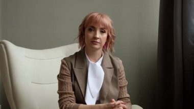 Business woman looks at camera and talks online at home office. Internet education.