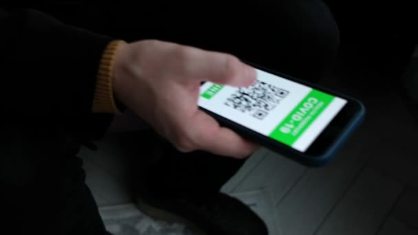 Muž ukazuje na kamerový telefon s imunitním digitálním pasem pro covid-19 na letišti. Smartphone s QR kódem v ruce. — Stock video