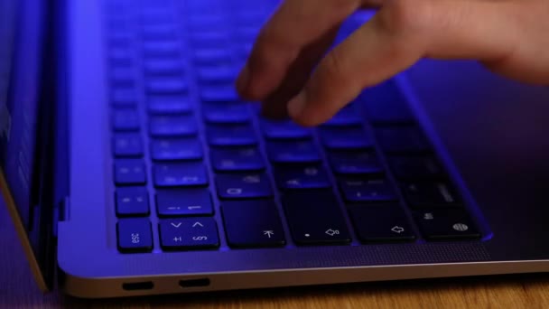 ノートパソコンのキーボードにコードを入力するハッカーの手、警察の緊急灯の光. — ストック動画