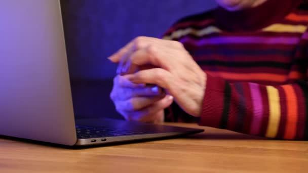 Современная пожилая женщина на пенсии делает покупки онлайн с помощью кредитной карты на ноутбуке. — стоковое видео