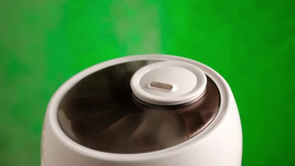 L'umidificatore genera vapore su sfondo verde. Depuratore d'aria funzionante a vapore. — Video Stock