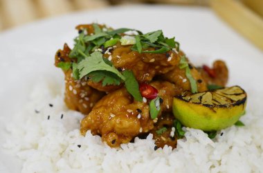 General Tso Asya çıtır çıtır tatlı susamlı tavuk Basmati, yaban pilavı ve taze soğanlı.