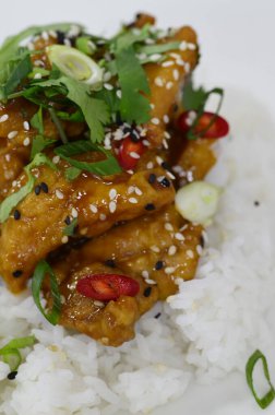 General Tso Asya çıtır çıtır tatlı susamlı tavuk Basmati, yaban pilavı ve taze soğanlı.