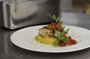 Pirinç ve sebzeyle servis edilen lezzetli balık yemeği.