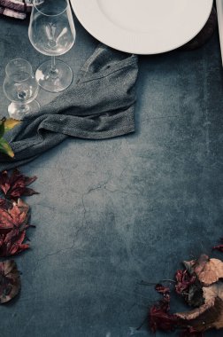 Ahşap arka planda sonbahar yaprakları ve şarap kadehleri.