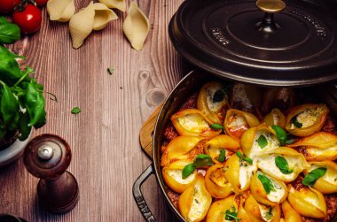 Fesleğen ve krem peynirle doldurulmuş makarna kabukları doğranmış fesleğen yaprakları serpiştirilmiş domates sosu, üst manzara.