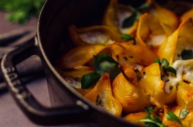 Fesleğen ve krem peynirle doldurulmuş makarna kabukları doğranmış fesleğen yaprakları serpiştirilmiş domates sosu, üst manzara.