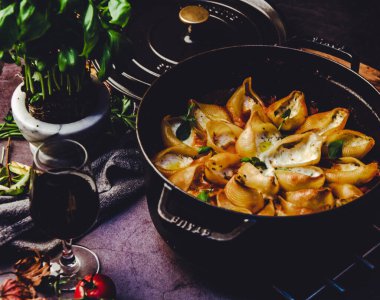 Fesleğen ve krem peynirle doldurulmuş makarna kabukları doğranmış fesleğen yaprakları serpiştirilmiş domates sosu, üst manzara.