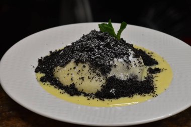 Germkndel - typical austrian dumpling filled with plum jam, served with poppy seeds and vanilla sauce