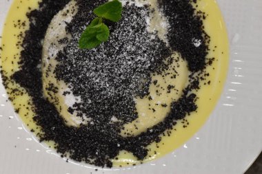 Germkndel - typical austrian dumpling filled with plum jam, served with poppy seeds and vanilla sauce