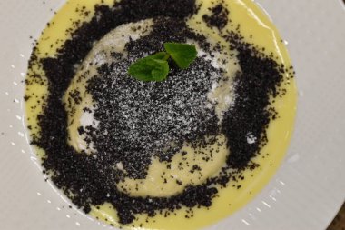 Germkndel - typical austrian dumpling filled with plum jam, served with poppy seeds and vanilla sauce