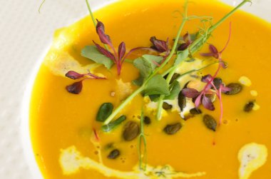 Sağlıklı kremalı sarı balkabağı çorbası otlu, restoranın arka planı öğle yemeği taze menü. 