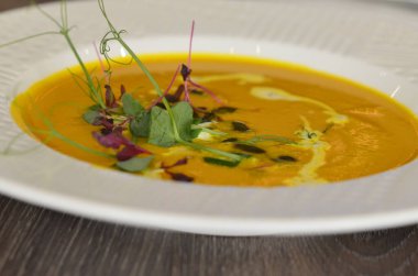 Sağlıklı kremalı sarı balkabağı çorbası otlu, restoranın arka planı öğle yemeği taze menü. 