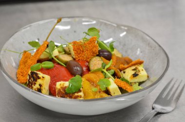 Kapari ve zeytin beyaz zemin üzerinde mavi bir kasede sarı ve kırmızı biber Salatası Kavrulmuş. Izgara sebze.