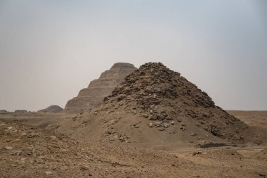 View to Userkaf pyramid with Step pyramid of Djoser at background.  Archeological remain in the Saqqara necropolis, Egypt