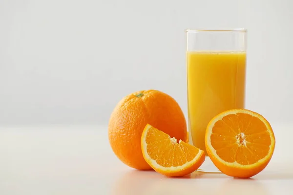 絞りたてのオレンジジュースと新鮮なジューシーなオレンジ自体のガラスを示す水平写真 半分と4分の1 活性化 ビタミンCが豊富で 完璧な一日の始まりと良い朝食 — ストック写真