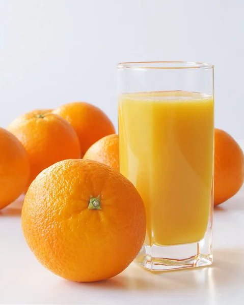 新鮮な絞りオレンジジュースと大量のオレンジのガラスがテーブルの上にあり 毎朝鮮やかなオレンジの色で飾られ ビタミンやエネルギーで飽和しているので それは楽しいです — ストック写真