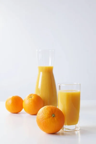 朝は右に開始する必要があります テーブルの上に絞りたてのオレンジジュースのガラスがあり 少し遠く ジュースとオレンジのジュース 一日中エネルギーとビタミンCのブースト — ストック写真