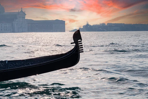 ヴェネツィアのラグーンと日没時にグランドキャナルで櫛帆の形をした伝統的な鉄のプロウを持つベネチアンゴンドラ 背景には ジュデッカ島とサン ジョルジョ マッジョーレ教会 — ストック写真