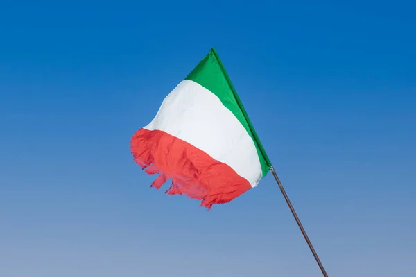 明るく晴れた青空の中で古くからのバッター 引き裂かれたイタリアの旗のフルート — ストック写真