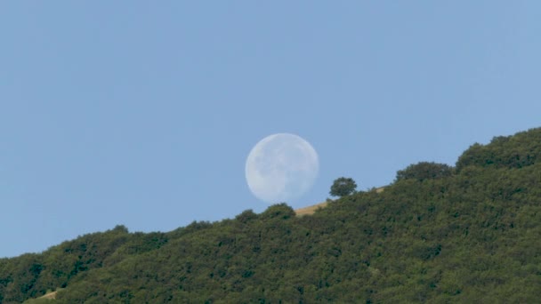 Timelapse Van Volle Maan Die Ondergaat Achter Een Berg Met — Stockvideo