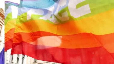 Barış dolu gökkuşağı bayraklı insanlar barış ve savaşa karşı bir gösteride ağır çekimde sallanıyorlar. Faşizmden kurtuluşun İtalyan yıldönümü