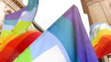 Barış dolu gökkuşağı bayraklı insanlar barış ve savaşa karşı bir gösteride ağır çekimde sallanıyorlar. Faşizmden kurtuluşun İtalyan yıldönümü