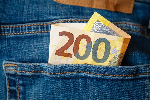 Bir kot pantolonun cebinde 200 avroluk fatura. Yatırımlar, kazançlar, nakit, kâr, zenginlik kavramları. Masanın altından ödendi. Kayıt dışı ödenmiş.