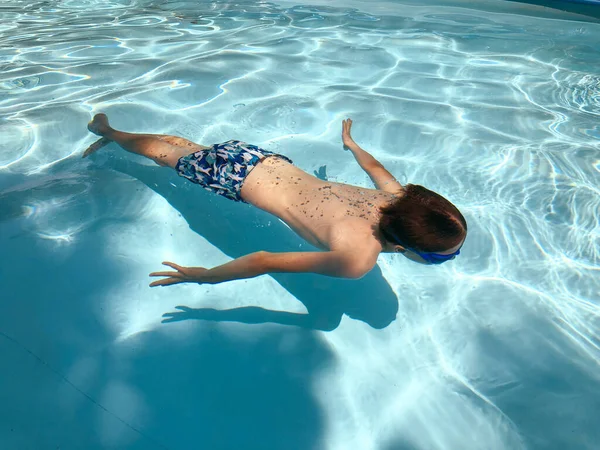 Boy Swimming Goggles Swims Underwater Pool Clear Blue Transparent Water — стоковое фото