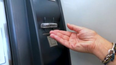 Bir kişi ATM 'den nakit kartını çeker. Bir kadın ATM 'den kredi kartını çekmiş..