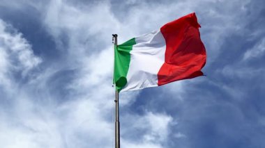 Italian flag waving in the blue sky in slow motion. Italy