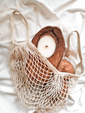 Hindistan cevizli el yapımı soya mumu ve eko torbasında ahşap fitil. Beyaz kumaş arka planda izole edilmiş. Sadece ekolojik malzemeler ve sıfır atık kavramı.