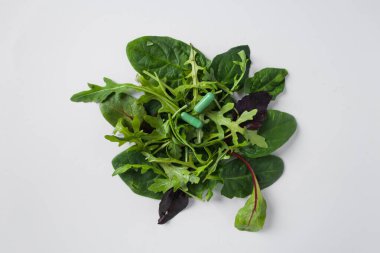 Yeşil roka yapraklı iki yeşil kapsül, marul, nane ve karışık salata. Günlük ilave doz. Sağlıklı beslenme.