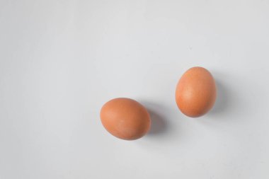 Beyaz arka planda izole edilmiş iki kahverengi çiftlik tavuğu yumurtası. Düşük karbonhidrat diyeti.