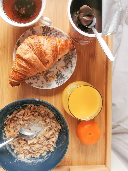 Egészséges étel reggel egy tál müzlivel, friss narancslével és egy csésze chikory-val. És egészségtelen francia croissant.. — Stock Fotó