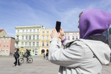 Genç adam, turist ona akıllı telefon tutuyor ve Avrupa 'nın merkezinde fotoğraf çekiyor..