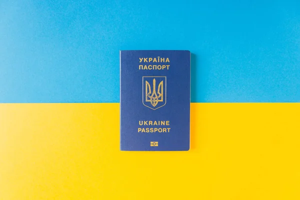 Ucrânia passaporte biométrico na bandeira nacional da Ucrânia. Liberdade cor azul acima e energizante cor amarela abaixo. — Fotografia de Stock