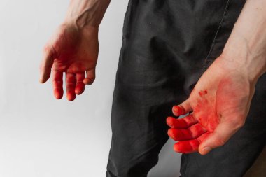 Beyaz arka planda kanlı elleri olan siyah pantolonlu bir adam. Bir katilin ve tecavüzcünün elleri..