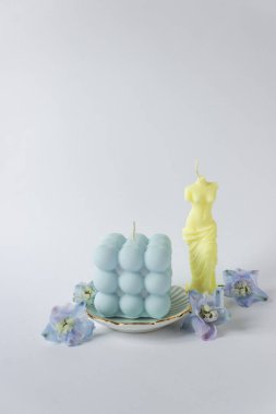 Kabarcık şeklinde iki soya mumu ve sarı ve mavi pastel renkte Venüs dişi gövdesi. Beyaz arka planda mavi çiçeklerle izole edilmiş. Ukrayna ulusal bayrağının renkleri.