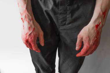 Beyaz arka planda kanlı elleri olan siyah pantolonlu bir adam. Bir katilin ve tecavüzcünün elleri. Kyiv yakınlarında Bucha 'da katliam. Ukrayna 'daki savaş ve şiddeti durdurun.