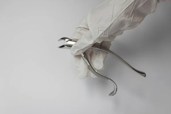 Человеческая Рука Белой Перчатке Держит Щипцы Удаления Зубов Белый Фон — стоковое фото