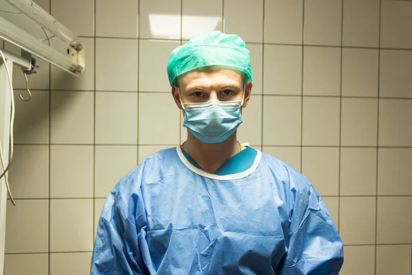 Portrait of veterinary surgeon in uniform - blue gown, hat and mask. Prepare to vet surgery in operation room. Medicine and health care concept.