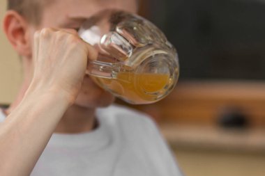 Beyaz tişörtlü beyaz sarışın genç adam barda lezzetli bira içip eğleniyor. Mesaj için yer var. Sağlıksız alkol içeceği. Bira ve arkadaşlarla yaz tatili.