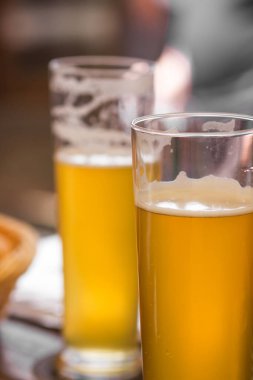 Czech bira fabrikasındaki piknik masasında köpüklü bir bardak light bira. Alkolik adamlar mayayla mayalanmış şerbetçiotu aromalı içecekler içerler. Hafta sonu arkadaşlarla toplantı. Oktoberfest kavramı.