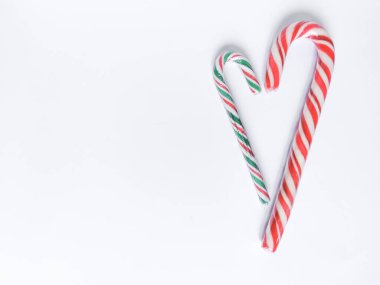 Kalp şeklinde Noel lolipoplarıyla kış romantizmi. Kırmızı, yeşil ve beyaz spiral çizgiler. Metin için yatay bileşim ve boşluk.