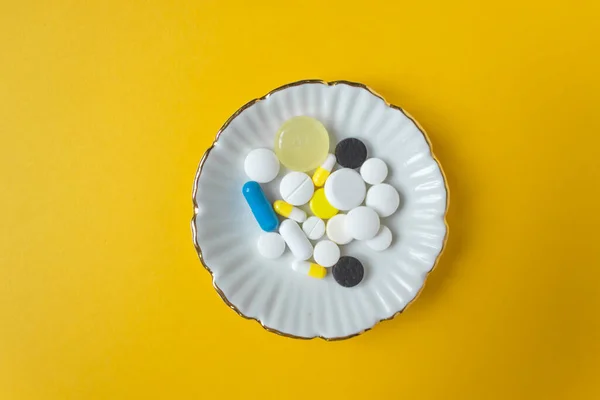 Placa Redonda Con Diferentes Píldoras Multicolores Cápsulas Gotas Fondo Amarillo — Foto de Stock