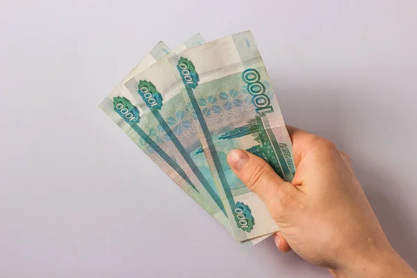 Mans hand holds russian money three thousand rubles on white background. Fall and devaluation of the russian ruble, crisis. World economic sanctions for Russia because it is a terrorist state.