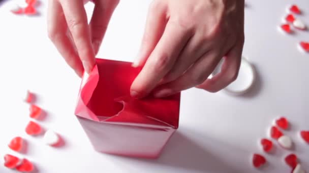 Les Mains Des Femmes Enveloppant Boîte Cadeau Dans Papier Rouge — Video