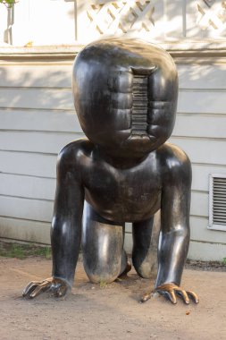 Prag, Çek Cumhuriyeti - 23 Haziran 2022: Prag 'daki Kampa Park Müzesinde Çek sanatçı David Cerny' nin ünlü heykel devi Sürünen Bebekler. Barkodlu koca bebek kafası. Sürrealizm sanat konsepti. 